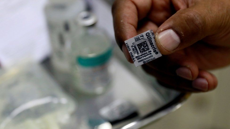 A Brazilian nurse shows a hydroxychloroquine pill