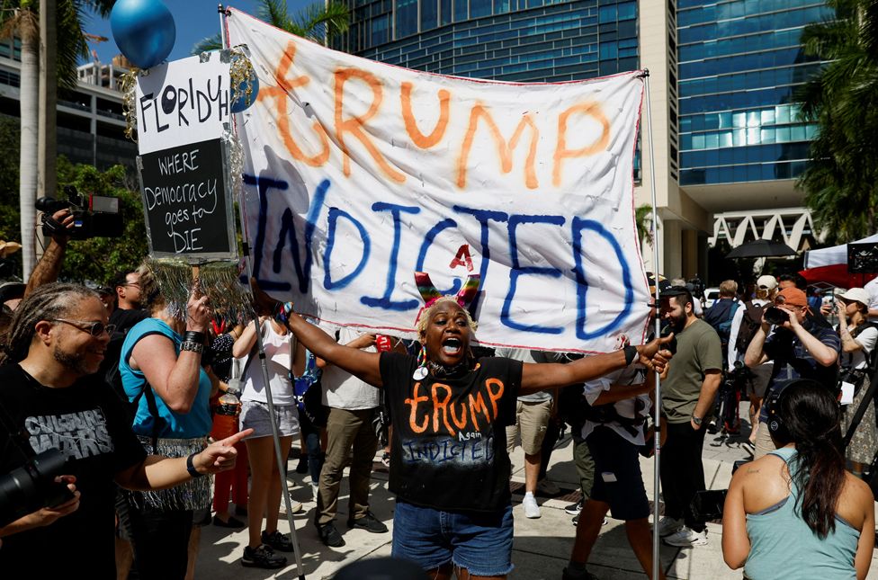 A person holds a banner near The Wilkie D. Ferguson Jr. United States Courthouse, on the morning former U.S. President Trump is to appear there on classified document charges, in Miami, Florida, U.S., June 13, 2023