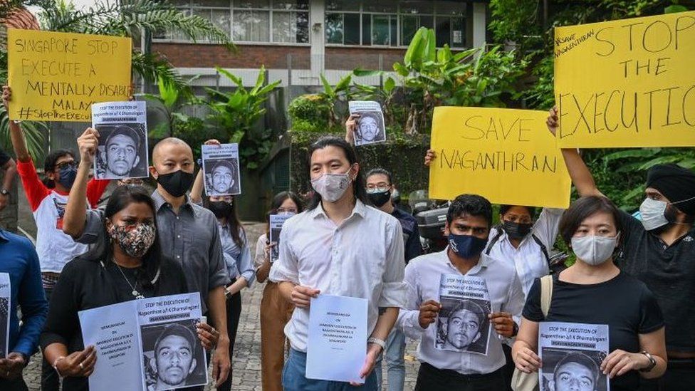 Активисты держат плакаты перед подачей меморандума в парламент в знак протеста против надвигающейся казни Нагантрана К. Дхармалингама