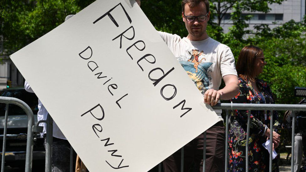 A person holds a 'Freedom Daniel Penny' sign outside the Manhattan Criminal Court on 12 May 2023