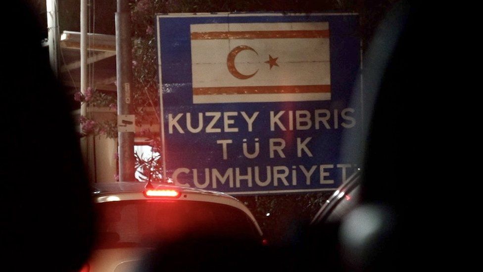 A sign announcing entry into Turkish-controlled northern Cyprus, photographed from inside a car at night