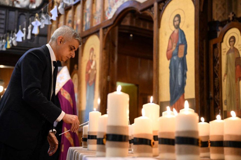 El alcalde de Londres, Sadiq Khan, enciende una vela, parte de las 52 velas que simbolizan las 52 semanas del conflicto, durante el servicio ecuménico de oración en la Catedral Católica Ucraniana, en Londres, el 24 de febrero de 2023