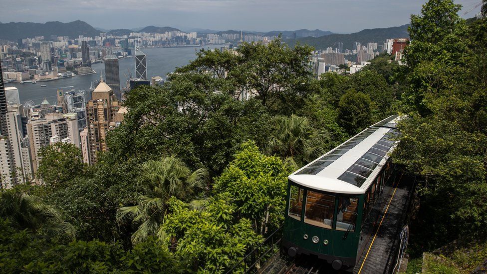 A 6th generation Peak tram travels above Hong Kong