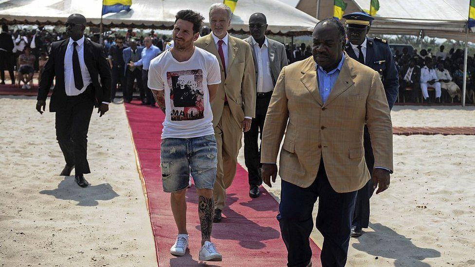 Argentinian soccer player and four-time FIFA Ballon d'Or winner Lionel Messi (C) is given a tour during the start of construction of the Port-Gentil Stadium by the President of Gabon, Ali Bongo Ondimba (R) in the Ntchengue district of Port-Gentil on July 18, 2015.