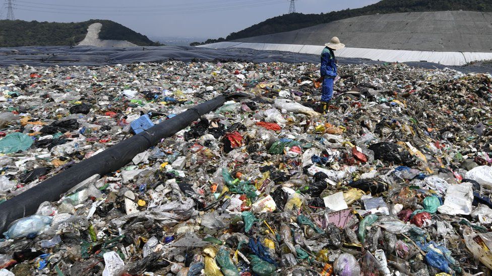 A worker prepares to cover the waste with a capping layer at the Tianziling landfill site on August 7, 2019 in Hangzhou