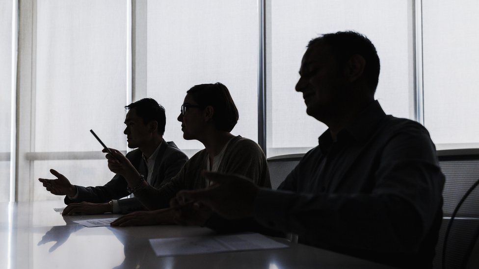 Silhouette of business people negotiating at meeting table