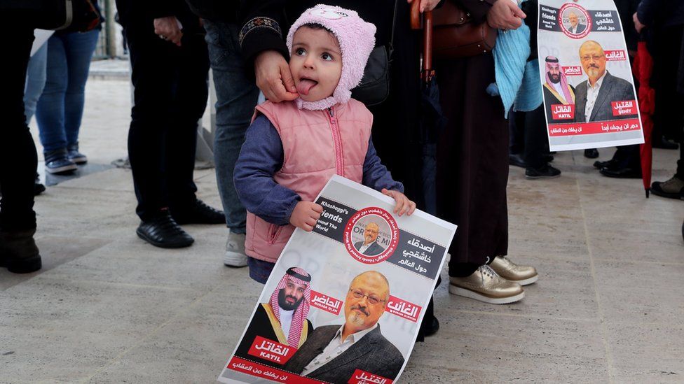 A child holds photos of slain Saudi journalist Jamal Khashoggi as people gather to perform an absentee funeral prayer at Fatih Mosque in Istanbul, Turkey, 16 November 2018