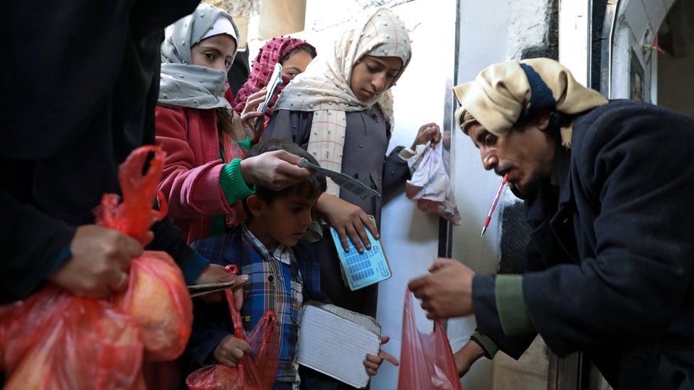 Фотография из архива, на которой женщины и дети стоят в очереди за едой на благотворительной кухне в Сане, Йемен (14 января 2021 г.)