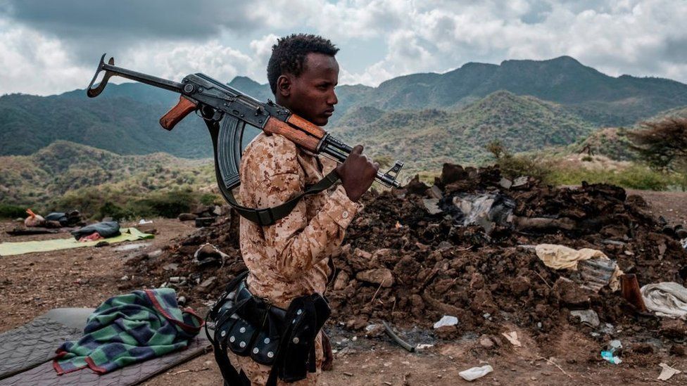 A member of the Afar Special Forces stands in front of the debris of a house in the outskirts of the village of Bisober, Tigray Region, Ethiopia, on December 09, 2020.Several houses in the village were damaged during the confrontations between the Tigray Forces and the Ethiopian Defense Forces.