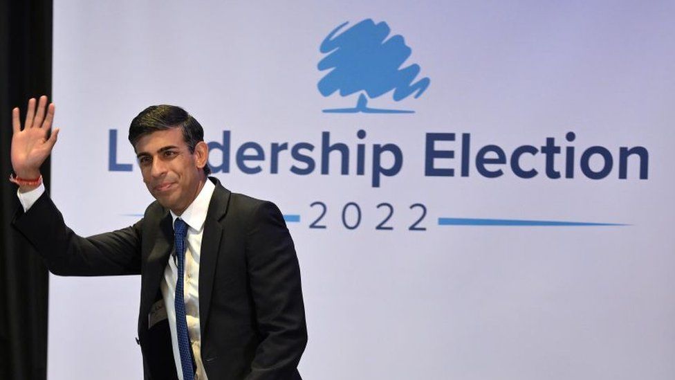 Rishi Sunak waves at a crowd during a hustings