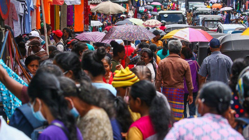 People gather to buy clothes on the busy street market of Maharagama, near Sri Lanka's capital Colombo