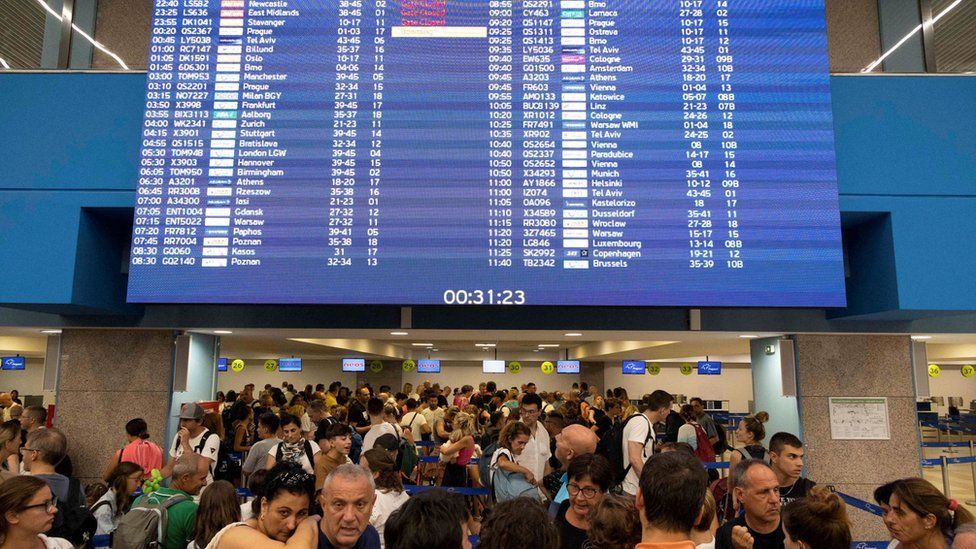 Tourists line up at check-in counters at Rhodes airport