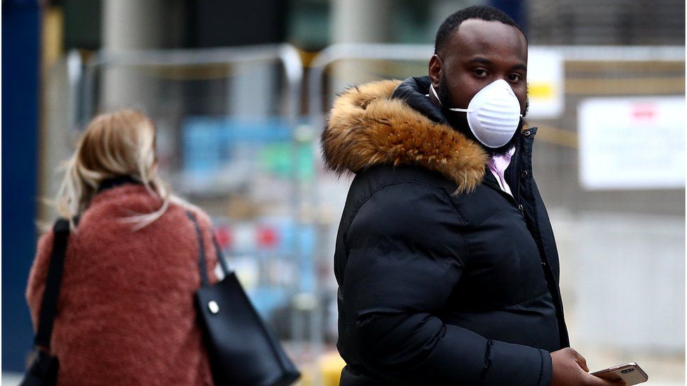 A man wearing a protective masks walks out of a Chanel store on its  reopening on the Champs Elysee avenue in Paris, France on May 11, 2020.  France began a gradual easing