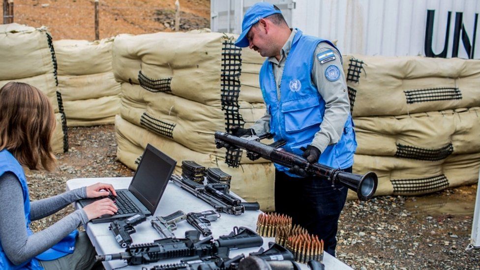 Handout photo released by the Revolutionary Armed Forces of Colombia (FARC) of a UN observers checking weapons handed by the FARC as part of the peace process in Buenos Aires, Cauca Department, 14 June 2017