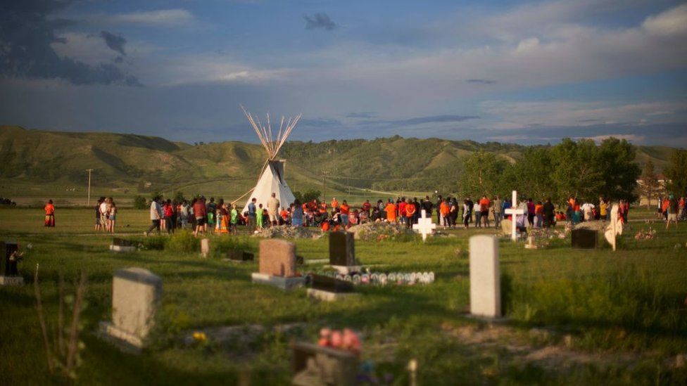 Hundreds of people gather for a vigil in a field where human remains were discovered in unmarked graves at the site of the former Marieval Indian Residential School on the Cowessess First Nation in Saskatchewan on June 26, 2021.