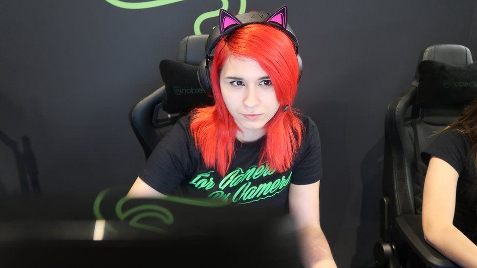A shot of Rage Darling in her computer chair with her gaming headphones on