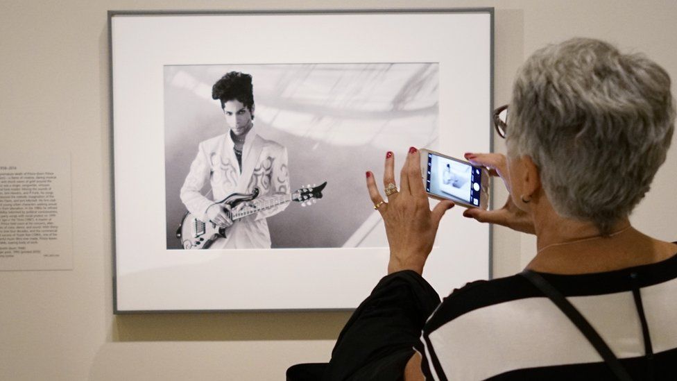 Посетители рассматривают фотографию музыканта Принса, сделанную Линн Голдсмит в 1993 году в Национальной портретной галерее Смитсоновского института, 22 апреля 2016 года, Вашингтон, округ Колумбия