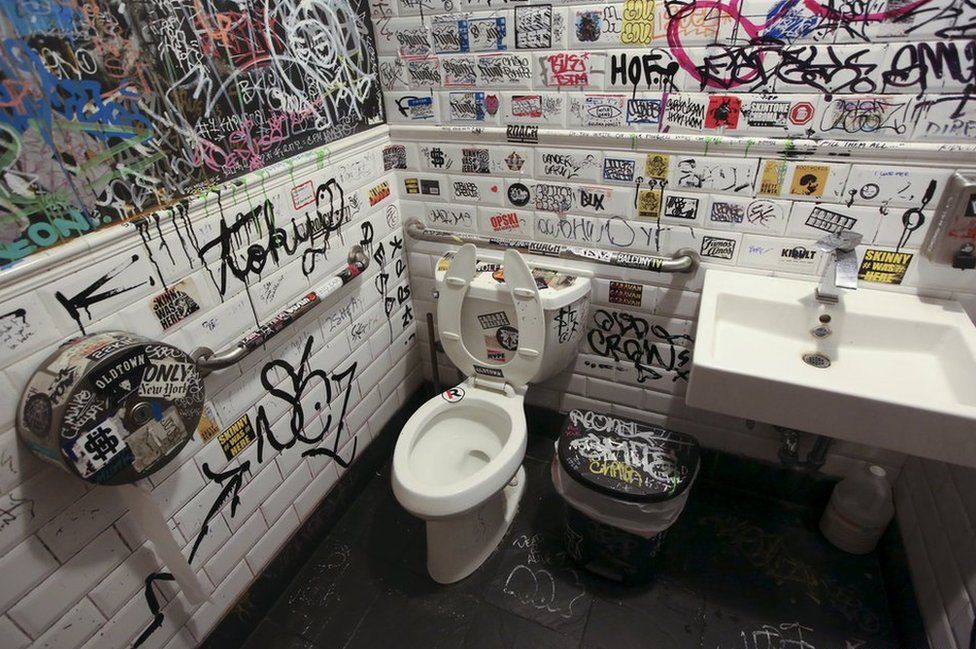 Graffiti is painted on the bathroom walls at a restaurant in the Williamsburg area of Brooklyn borough in New York, United States