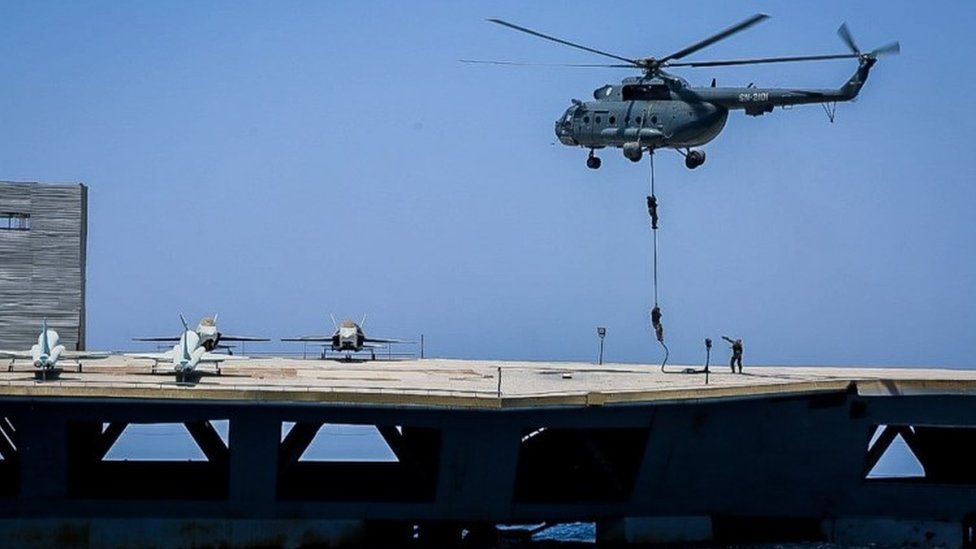 Iranian soldiers jump on the mock carrier