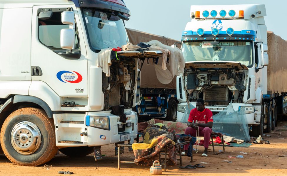 Drivers rest next to parked lorries near the border town of Malanville, Benin - Wednesday 16 August 2023