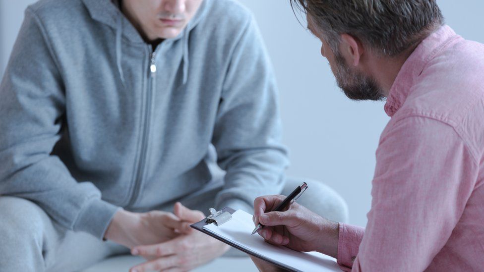 Psychologist interviewing his patient during a therapy counselling session