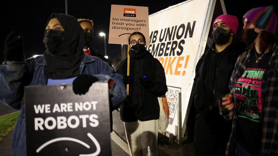 People hold up signs during a rally outside the Amazon warehouse, in Coventry, Britain, on 25 January 2023