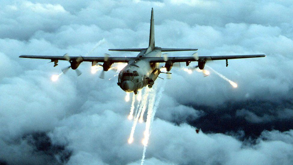 File photo of an AC-130 gunship firing flares in several directions mid-flight