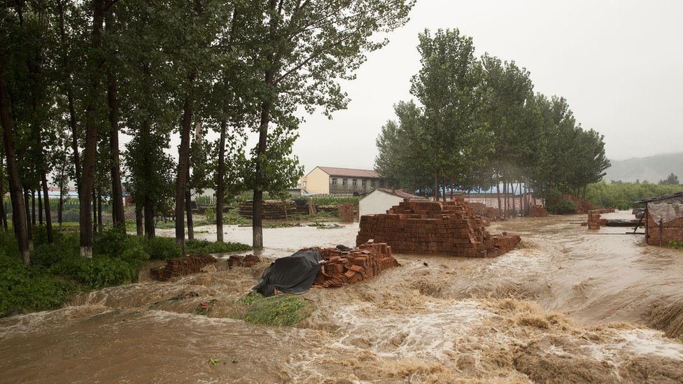 Flood waters tear through a village on July 19, 2016 at Linzhou, Henan Province, China.