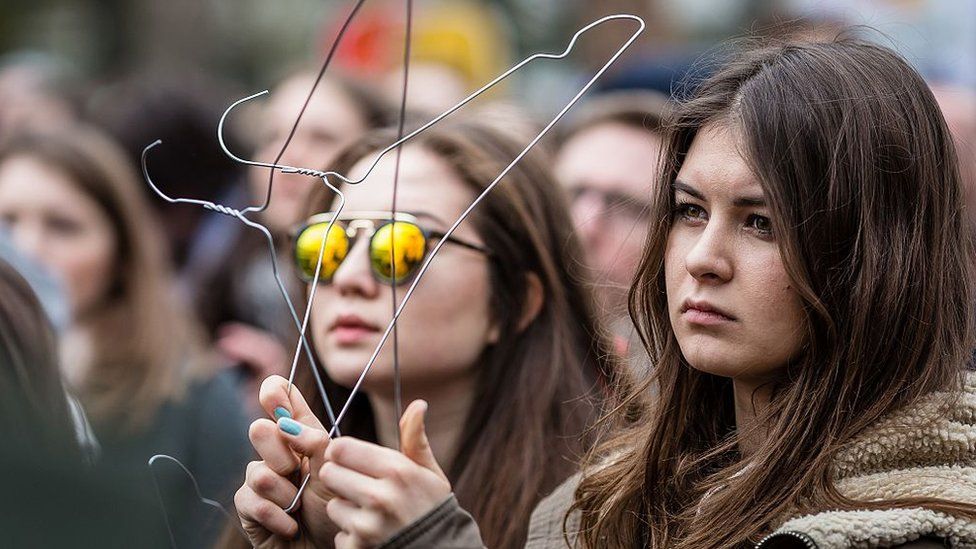 A woman holds coat-hangers as a symbol of illegal abortion during an anti-government, pro-abortion demonstration in front of parliament in Warsaw on 9 April 2016