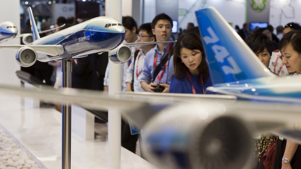 Visitors at the Singapore Airshow look at model Boeing airliners.