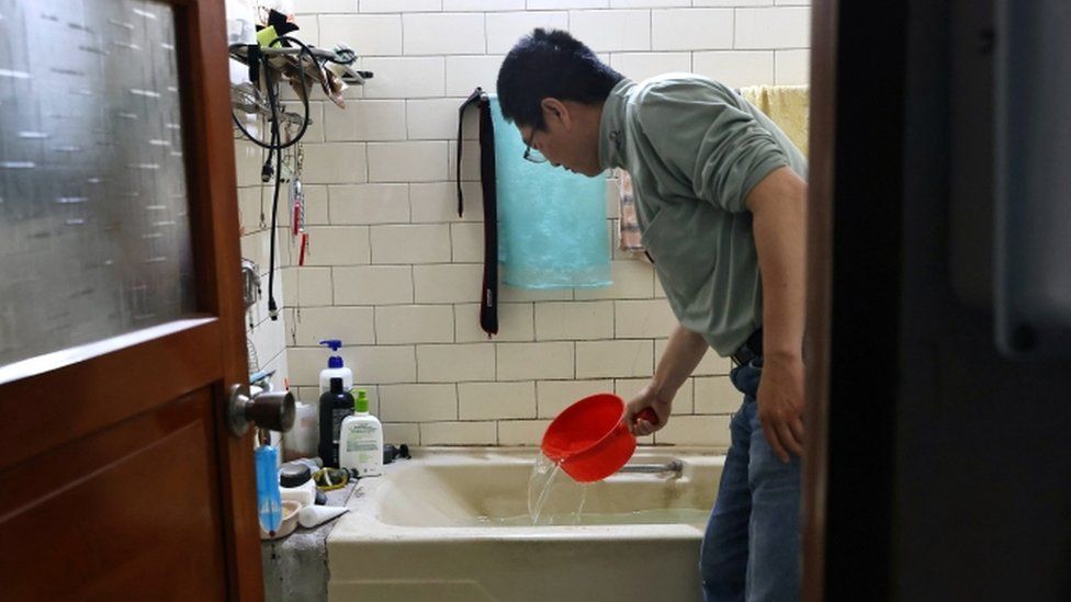 A man scoops water from a bathtub, where he stores water amid water rationing during an island-wide drought, in Hsinchu, Taiwan on March 12, 2021