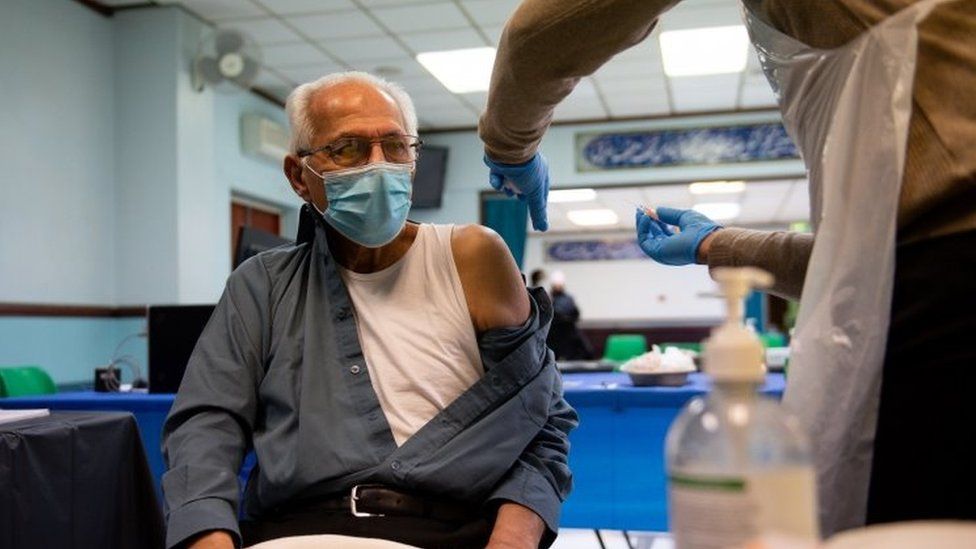A man wearing a facemask while getting vaccinated