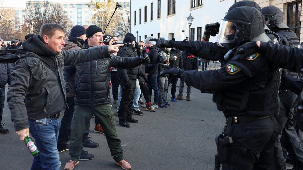 Офицеры немецкой полиции по охране общественного порядка с протестующими во время демонстрации против правительственных мер по сдерживанию распространения коронавирусной болезни (COVID-19) в Магдебурге, Германия, 8 января 2022 г.