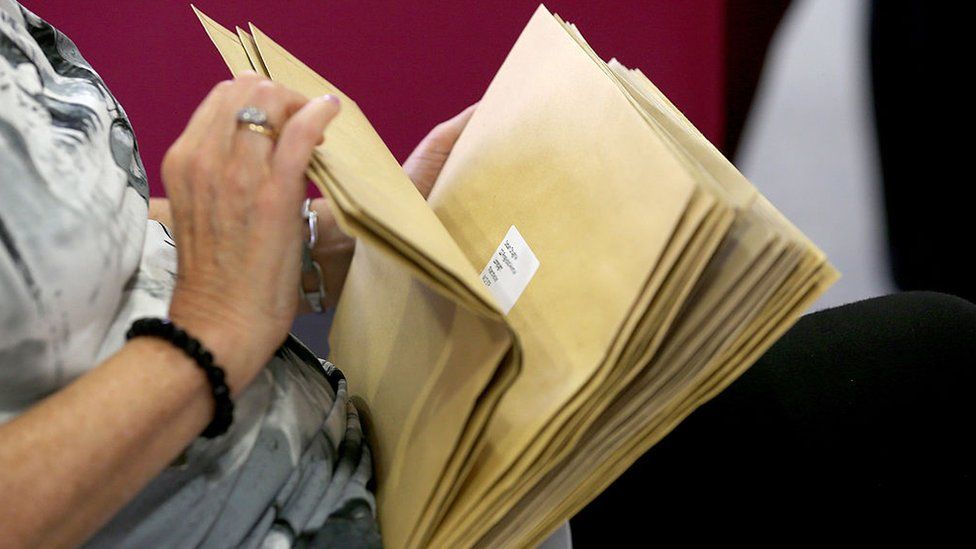 Teacher holding results envelopes