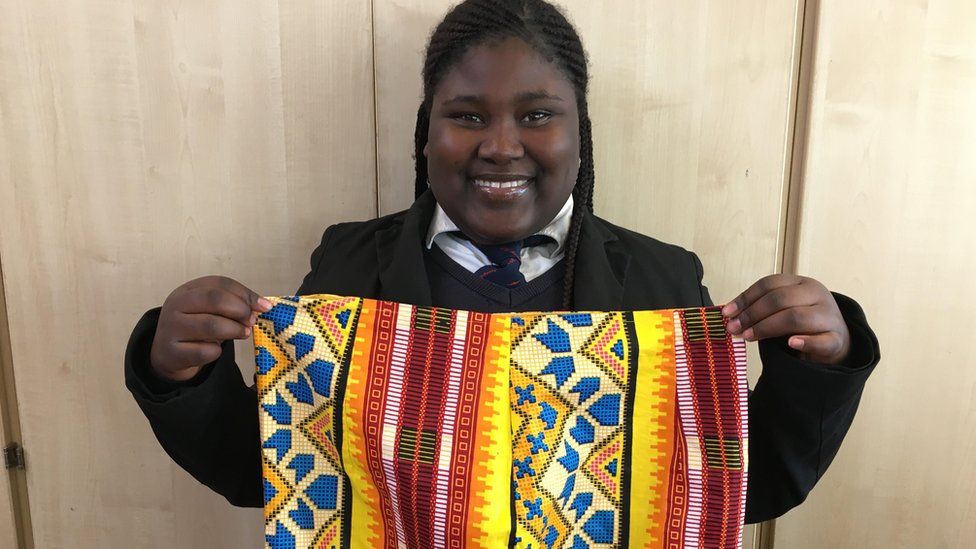 Image of Sainabu Nije holding a colourful Gambian skirt.