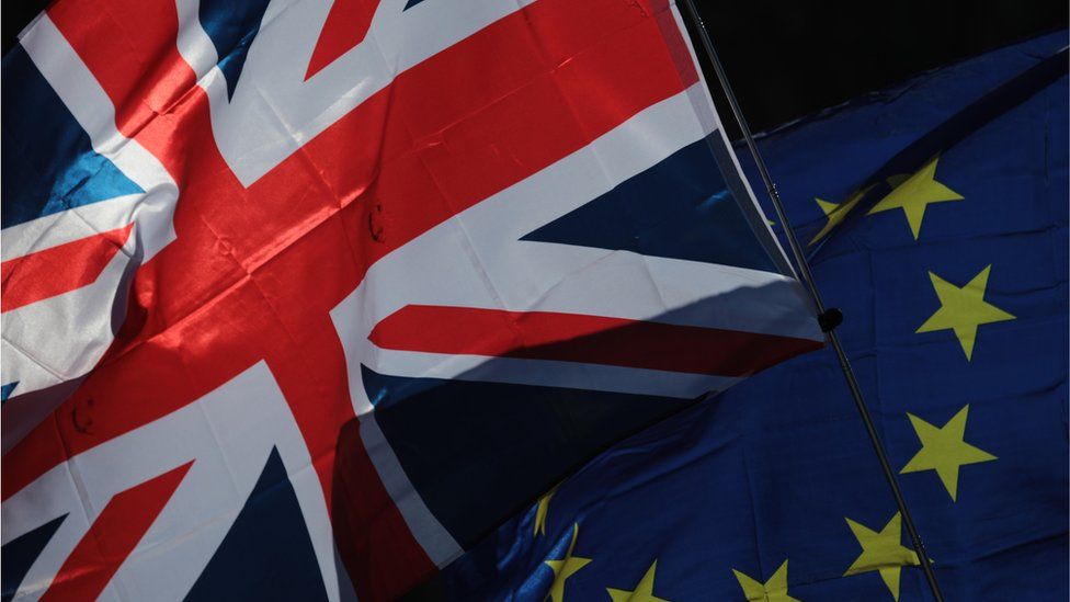 A Union flag, also known as Union Jack, left, and a European Union (EU) flag fly during a Unite for Europe march to protest Brexit in central London, U.K.