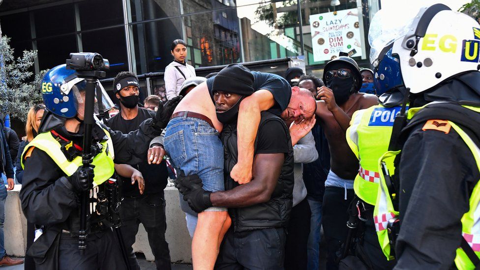 A protester carried an injured counter-protester to safety, near Waterloo station
