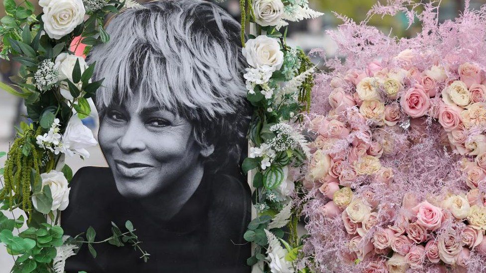 A photograph of Tina Turner adorned with flowers
