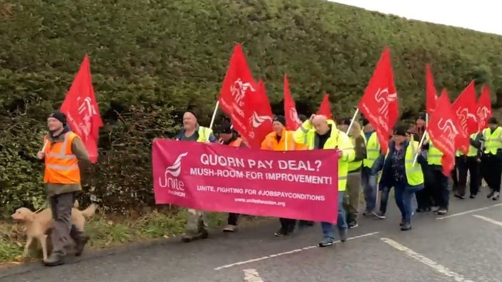 Workers marching outside the site this morning