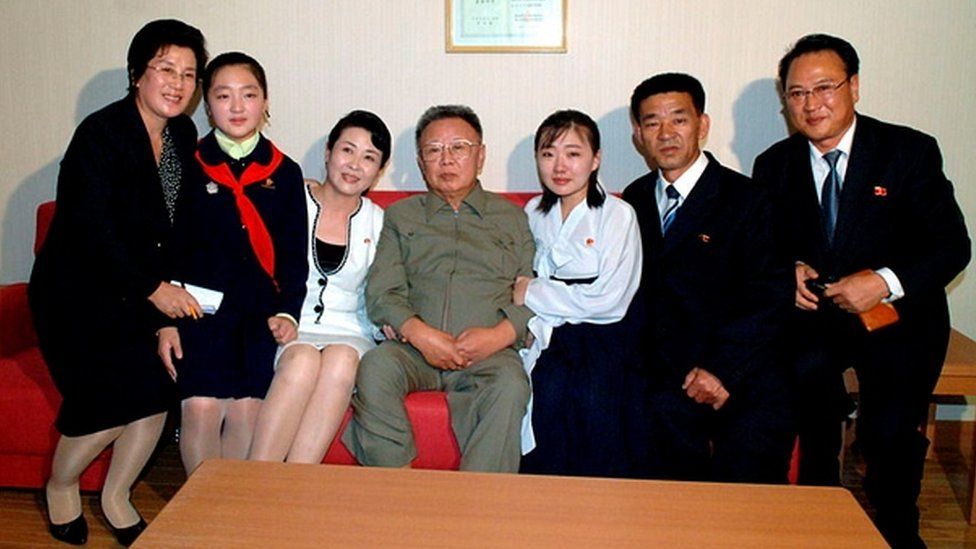 A family taking a photo with Kim Jong-il