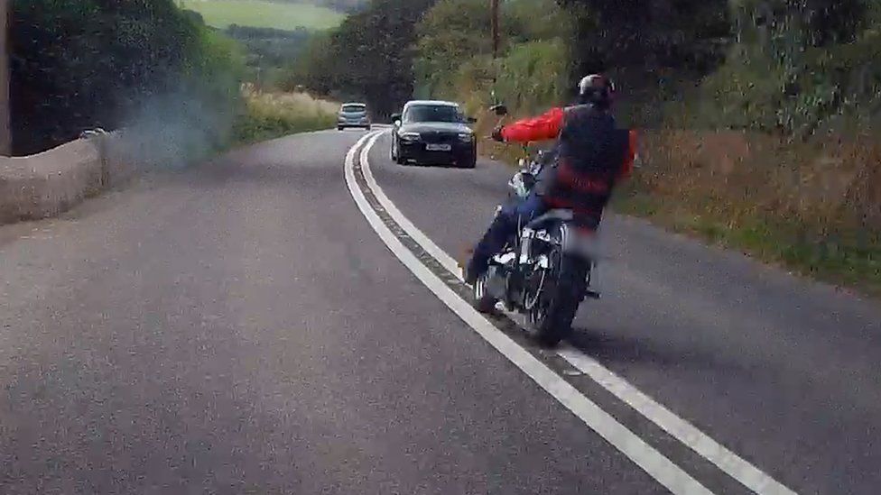 A motorcyclist crossing double white lines
