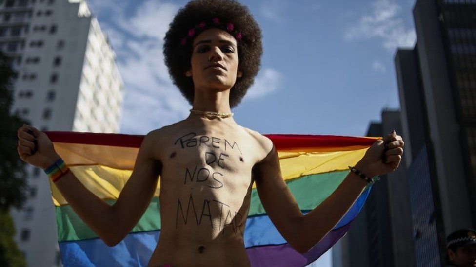 A man with the words "Stop killing us" takes part in Sao Paulo's Gay Pride parade