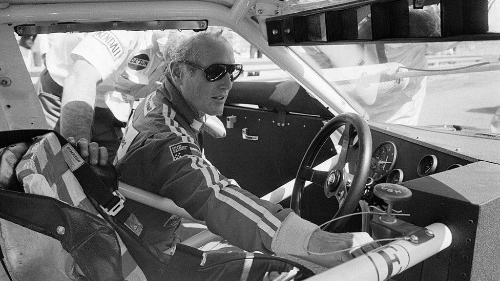 Покойная голливудская звезда Пол Ньюман проверяет свой гоночный автомобиль Datsun.
