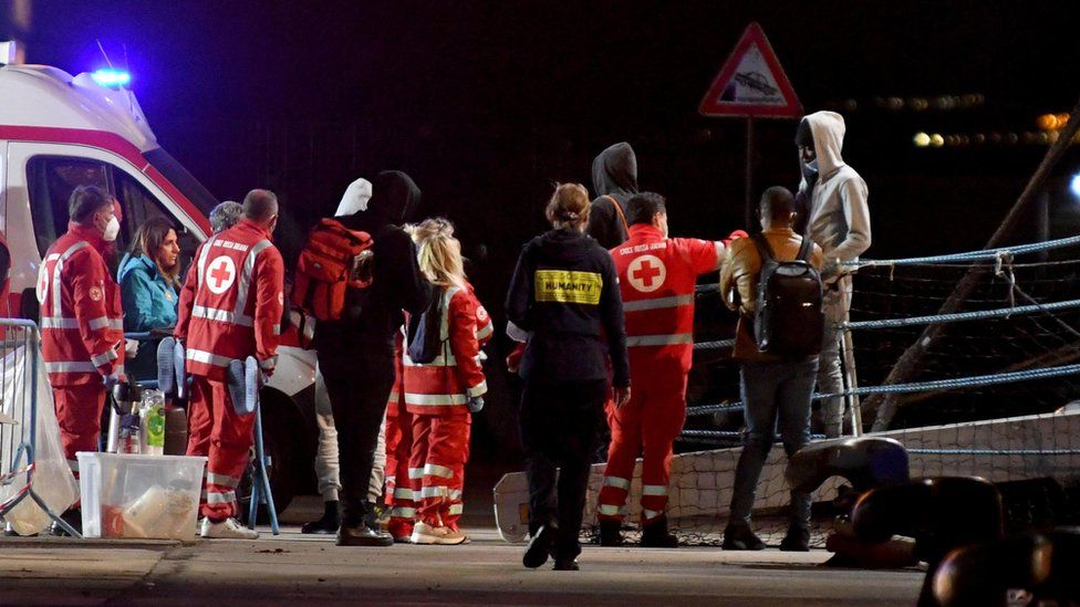 Police officers and Red Cross members help migrants disembark from the ship Humanity 1 of the SOS Humanity NGO, at the port of Catania, Sicily, Italy, 06 November 2022