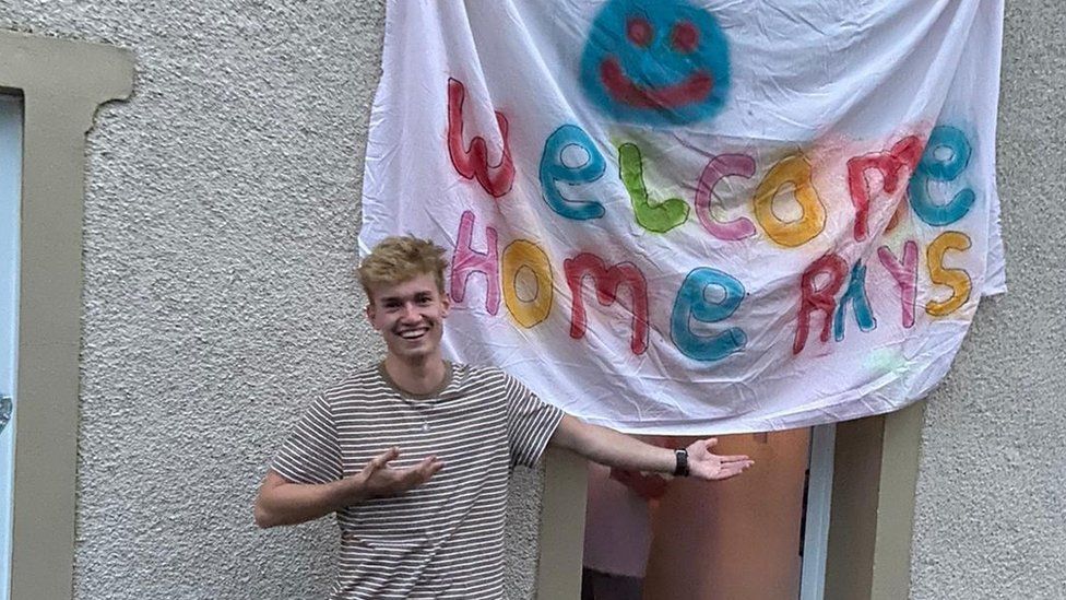 Mr James outside his house with a banner