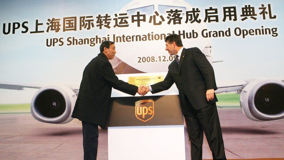 A Chinese official shakes hands with a UPS boss