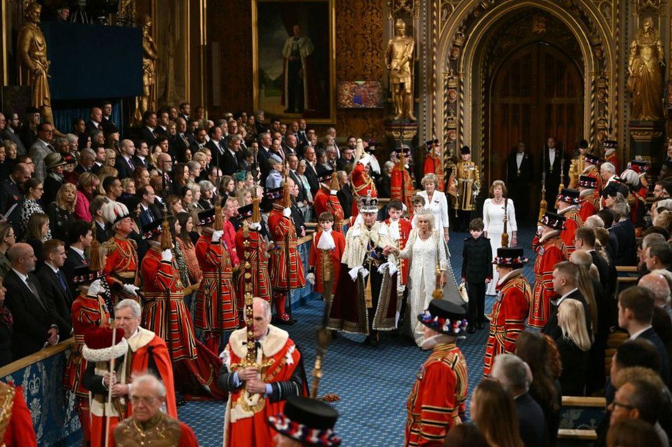 Britain's King Charles III, wearing the Imperial State Crown and the Robe of State, and Britain's Queen Camilla, wearing the George IV State Diadem, process through the Royal Gallery during the State Opening of Parliament at the Houses of Parliament, in London, on November 7, 2023.