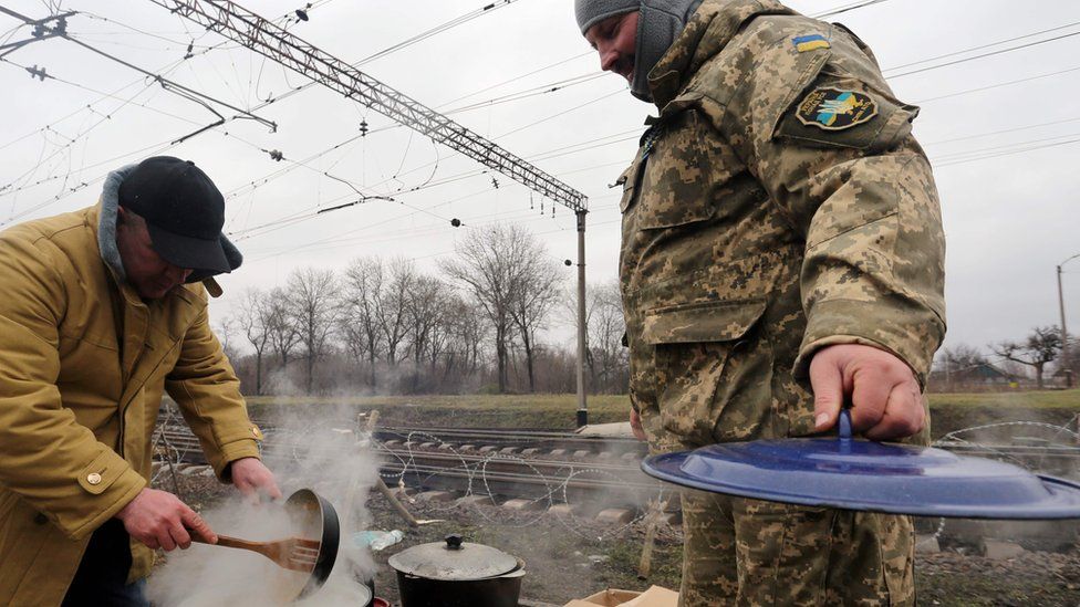 Ukrainian nationalist protesters and military veterans cook as they take part in a blockade against ongoing trade with Russian-backed insurgents, on February 23, 2017, in Kryvyi Torets railway station, Donetsk region