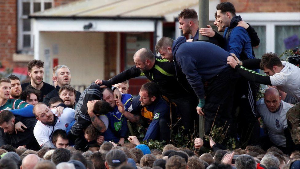 Players fight for the ball during the annual Shrovetide football match in Ashbourne