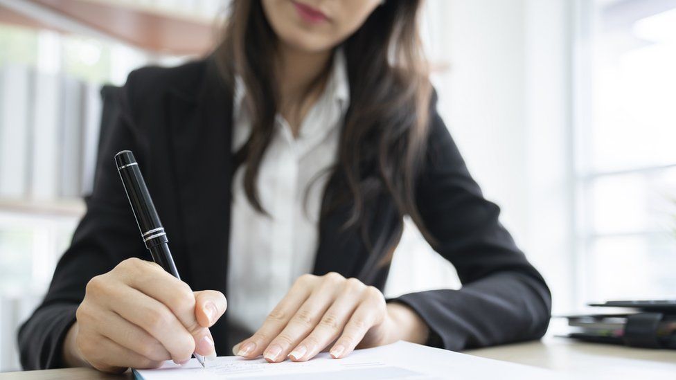 A woman signing a non-disclosure agreement (stock image)